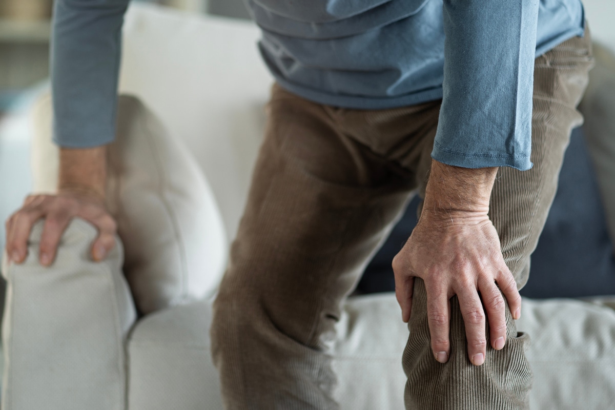 man holding his knee - joint pain weakness from glp-1 medication concept