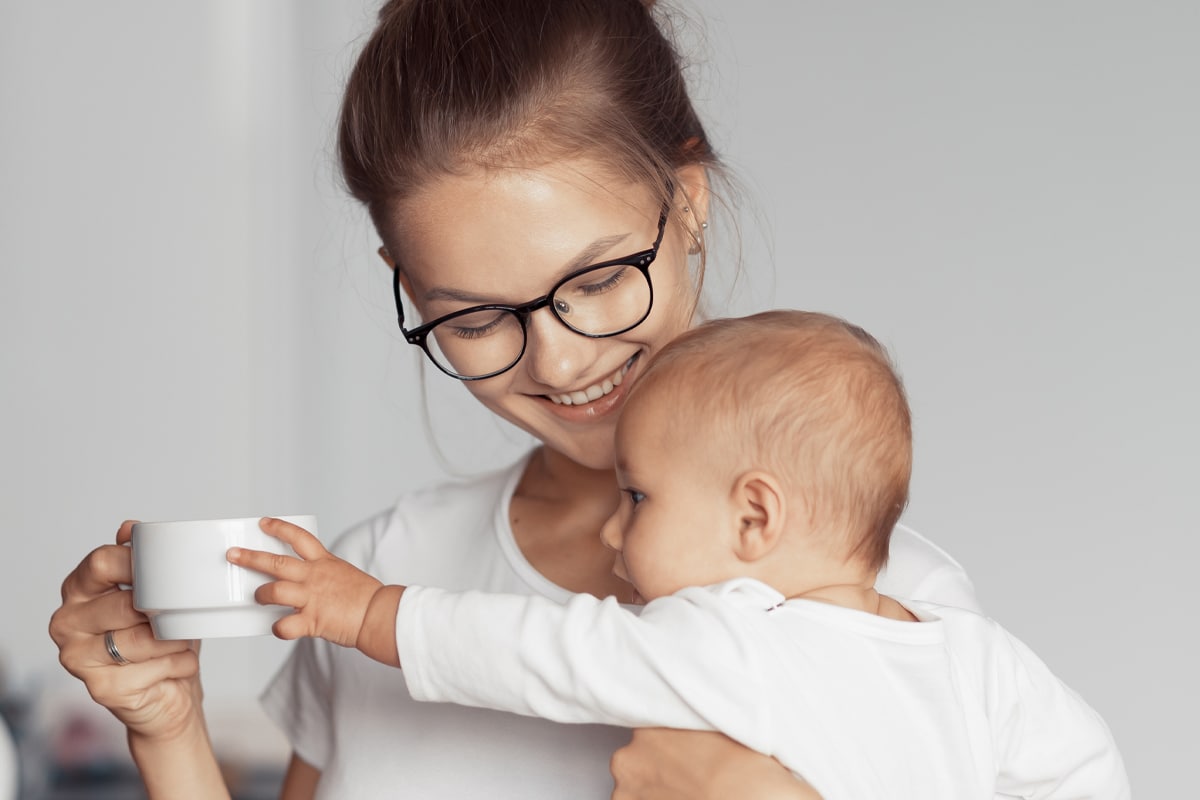 mom with newborn drinking tea