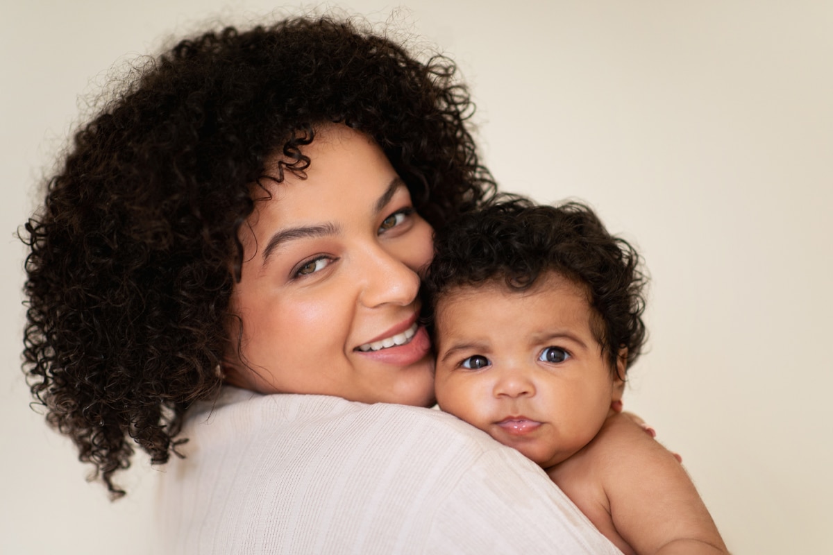 mother snuggling newborn baby