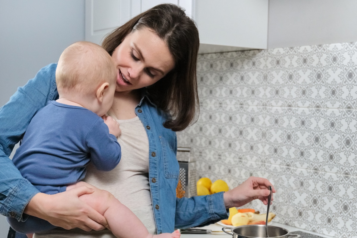 new mom cooking with baby on her hop